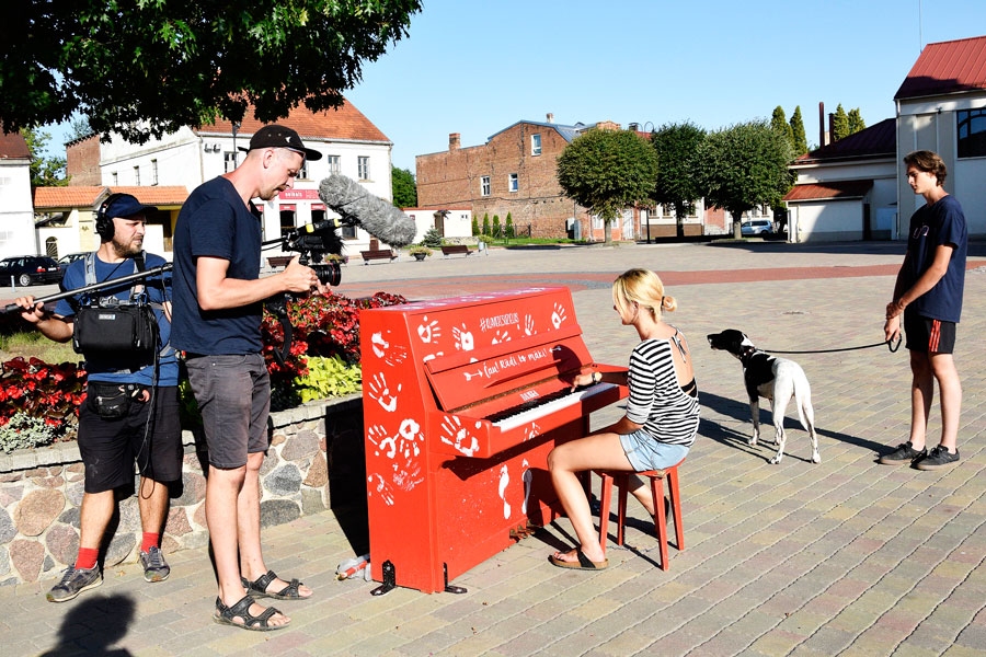Helēna, Roberts ar suni Urgu un filmēšanas grupa pie klavierēm Bauskas rātslaukumā, kuras 
pilsētvidei sarūpējis baušķenieks  Matīss Kataņenko.
Autors: Ivars Bogdanovs