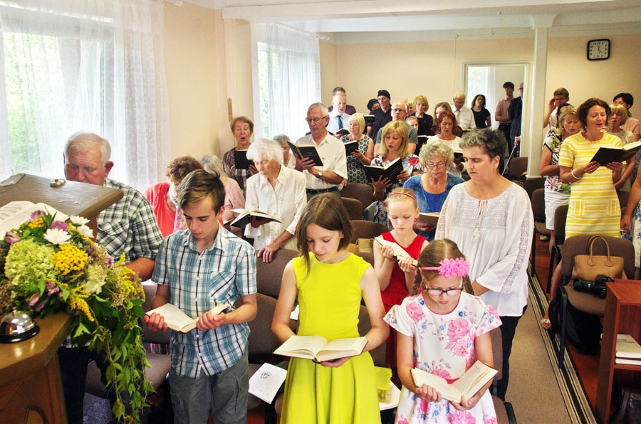 Svētku dievkalpojums Bauskas septītās dienas adventistu dievnamā. Priekšplānā – Ezeriņu ģimenes bērni, kuri baznīcas dārzā iekārtoja savu mākslas darbu izstādi. Aizmugurē stāv viņu mamma Antra Ezeriņa, kura kopā ar Hariju Zablocki veic draudzes vecāko pienākumus.
Autors: Harijs Zablockis