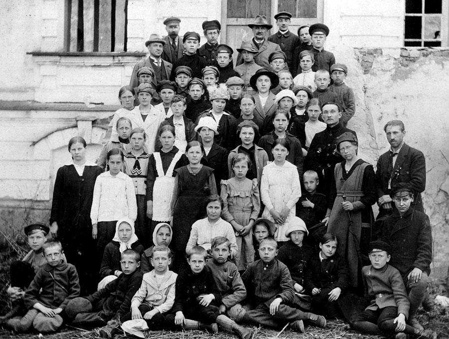 Bauskas pamatskolas un reālģimnāzijas audzēkņi ar pedagogiem pie Rundāles pils. Abi skolu pārziņi ar hūtēm galvā: augšējās rindas vidū – J. Žibeika, rindu zemāk pirmais no kreisās – J. Pērkons. 1919./1920. mācību gads.
Autors: no Bauskas muzeja krājuma