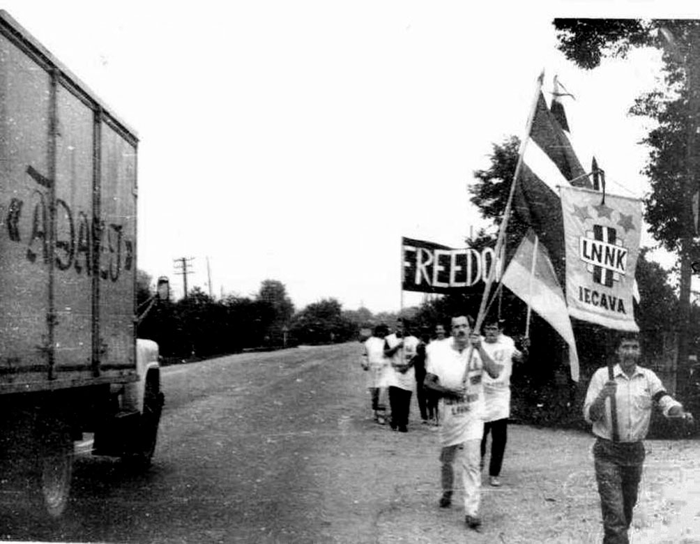LNNK Iecavas nodaļas biedri ceļā uz mītiņu Rīgā. LNNK vimpeli nes Aivars Šulcs (pirmais no labās), ar Latvijas karogu – Raimonds Sietiņš.