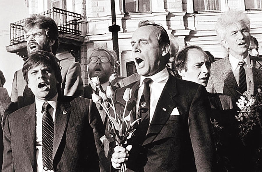 No Bauskas vēlēšanu apgabala ievēlētais Augstākās Padomes deputāts Georgs Andrejevs ar tulpēm rokā dzied Latvijas himnu tautas manifestācijā Daugavmalā 1990. gada 4. maijā pēc Neatkarības deklarācijas pieņemšanas. Kopā ar viņu deputāti Imants Ziedonis, Jānis Gavars, Andris Tomašūns, Pēteris Laķis un Ivars Krastiņš.
Autors: no vietnes  https://www.doctus.lv