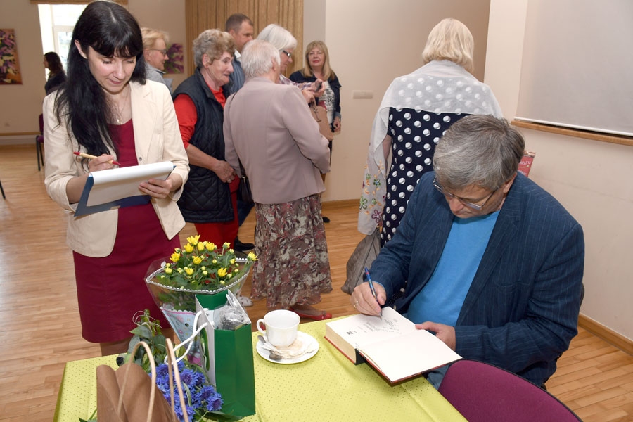 Sarīkojums Iecavas kultūras namā. E. Virzas Iecavas bibliotēkas vadītājas pienākumu izpildītāja Jolanta Ignate pārskata reģistrēto dalībnieku listi, savukārt Arno Jundze grāmatā «Sarkanais dzīvsudrabs» ieraksta pateicību un novēlējumu iecavniekiem.
Autors: Ivars Bogdanovs