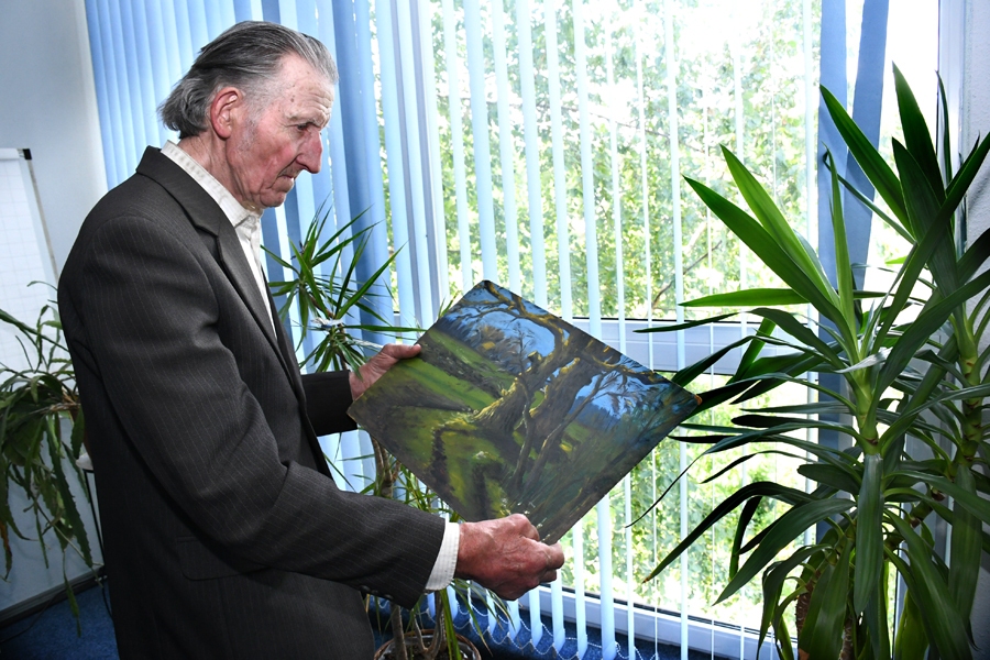 Edvīns Strazdiņš demonstrē savu gleznu, kurā attēlojis Mežotnes ozolus