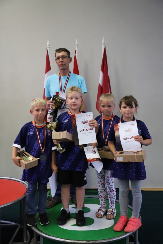 Trešās vietas ieguvēji, U8 grupas dambretisti – Markuss Kaļķis (no kreisās), Verners Fībigs, Rūta Arāja un Milana Subača – kopā ar treneri Jāni Štālu.
Autors: no dambrete.lv.