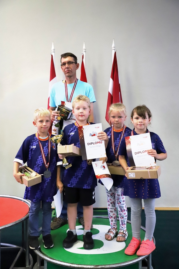 Trešās vietas ieguvēji, U8 grupas dambretisti – Markuss Kaļķis (no kreisās), Verners Fībigs, Rūta Arāja un Milana Suboča – kopā ar treneri Jāni Štālu.
Autors: no dambrete.lv.