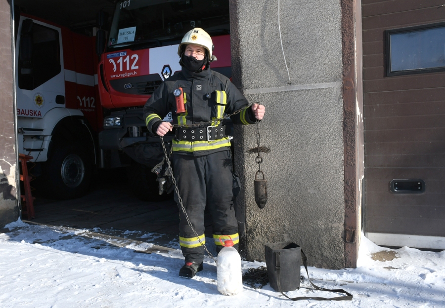 VUGD Bauskas daļas vada komandieris Jānis Paškevičs demonstrēja, ka degošu sodrēju dzēšanai izmanto tehnisko sāli, nevis ūdeni, kas temperatūras kontrasta dēļ var radīt plaisas skurstenī. Pēc tam darbā tiek laista skursteņslauķa birste ar desmit kilogramu smagu atsvaru.
Autors: Ivars Bogdanovs