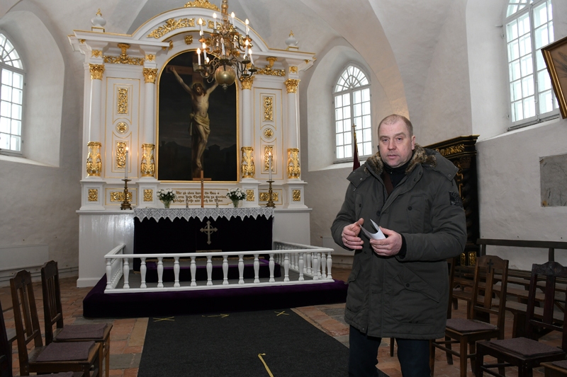 Draudzes vecākais Guntis Macpans atjaunoto altāri salīdzina ar līgavu kāzu kleitā.
