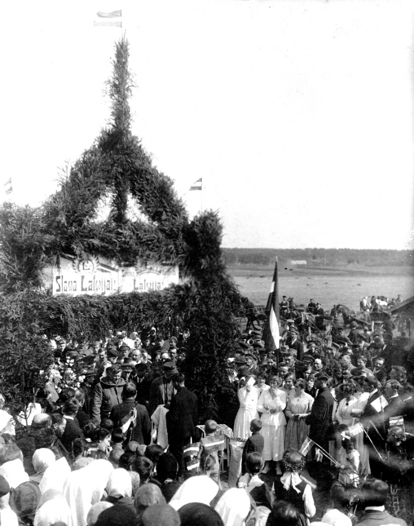 Ministru 
prezidenta Kārļa Ulmaņa svinīga sagaidīšana uz kādreizējās Latvijas-Lietuvas robežas pie Budbergas pagasta «Slokām» 1921. gada 26. aprīlī. Kreisajā pusē zem goda vārtiem K. Ulmanis biezā mētelī ar nolaistu kapuci, sagaidītāji visai vasarīgi ietērpti. Viens no pirmajiem sagaidītājiem ir ar maizes klaipu uz linu dvieļa, tālāk kāds puisītis ar torti. Pasākums notika par godu Budbergas pagasta pievienošanai Latvijai.
Autors: no Bauskas muzeja krājuma.