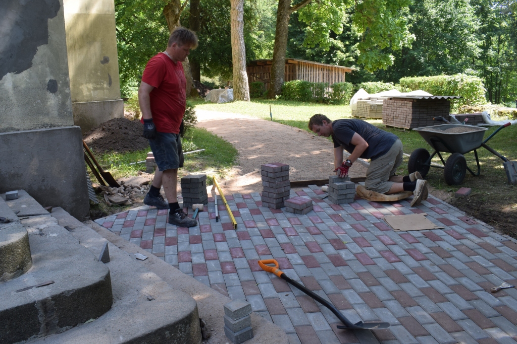 Pie Vecumnieku baznīcas top bruģēta taka. Darbus kopā ar citiem veic Roberts Otomers (no labās) un Agris Celiņš.
Autors: Žanna Zālīte