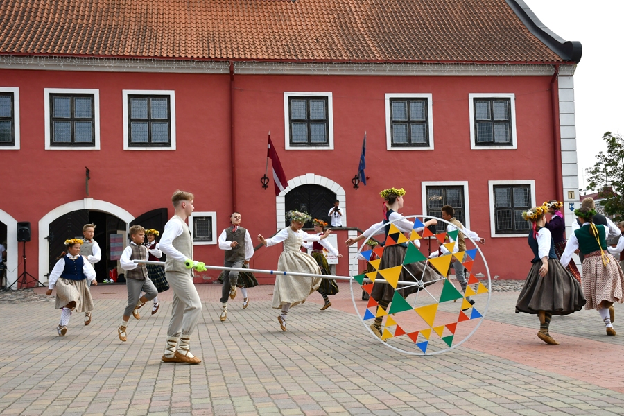 Jaunieši izdejo «Saulesviju» Bauskas rātslaukumā.