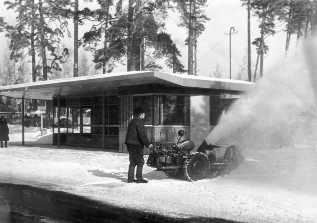 Pieturvietas tīrīšana ar rokas mehanizēto sniega tīrītāju. 1970. gadi. Foto no Latvijas Ceļu muzeja.